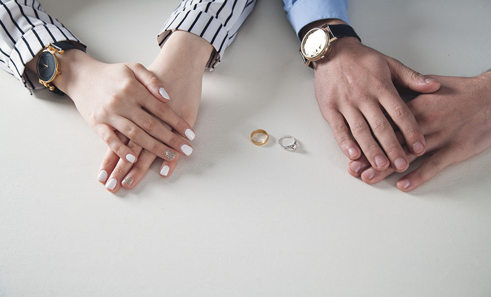 Man and woman hands with ring on desk