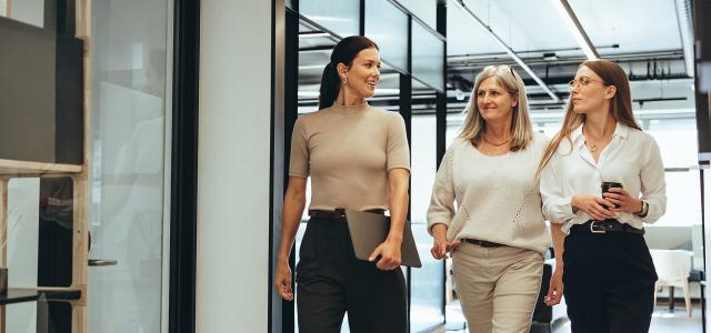 Three Businesswomen Walking Together in an Office